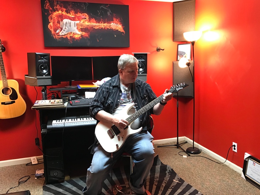 Cameron Todd plays guitar in his studio